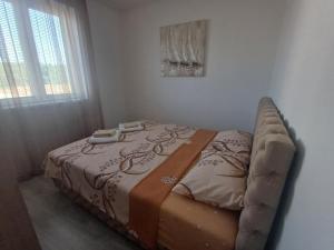 a bed sitting in a room with a couch at Apartman Silver Lux Srebrno jezero in Veliko Gradište