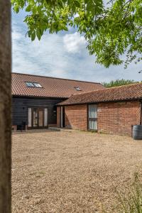 an external view of a brick building with a yard at The Stables - Holly Tree Barns in Halesworth
