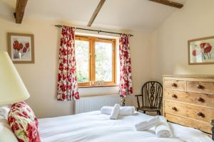um quarto com uma cama e uma janela em The Stables - Holly Tree Barns em Halesworth