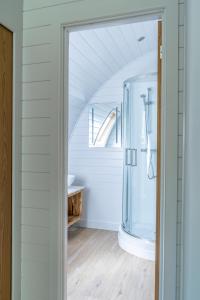 a bathroom with a shower and a sink at Glamping Pod Two - Holly Tree Barns in Halesworth