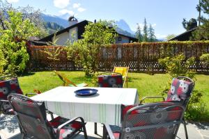 - une table et des chaises dans la cour d'une maison dans l'établissement Alpenheim, à Garmisch-Partenkirchen