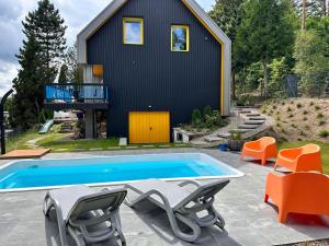 a house with a swimming pool and some chairs at HonoLulu Dom Wakacyjny z balią, sauną i basenem in Kłaczno