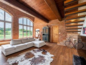 a living room with a couch and a brick wall at Holiday Home La Bell'aria by Interhome in Tonco