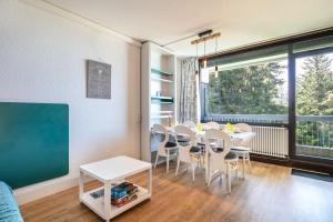 a dining room with a table and chairs and a chalkboard at L'Ascension - Studio vue montagne in Chamrousse