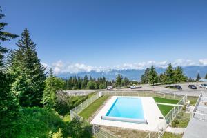 une villa avec une piscine et un parking dans l'établissement L'Ascension - Studio vue montagne, à Chamrousse