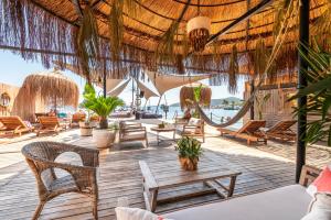 Una terraza estilo resort con sillas y mesas y vista al océano. en Elista Hotel & Spa, en Golturkbuku