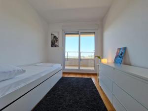 een witte slaapkamer met een bed en een raam bij Luxury Penthouse "MANK" with private Parking in Split