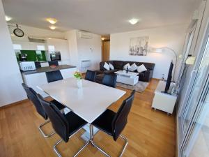 een eetkamer en een woonkamer met een tafel en stoelen bij Luxury Penthouse "MANK" with private Parking in Split