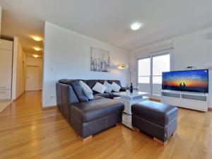 een woonkamer met een bank en een flatscreen-tv bij Luxury Penthouse "MANK" with private Parking in Split