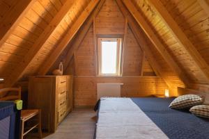 1 dormitorio en una cabaña de madera con cama y ventana en MP 50 - Strandvogt 3 Komfort en Dorum-Neufeld