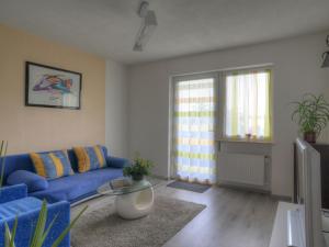 sala de estar con sofá azul y mesa en Holiday Home Möllmann by Interhome en Bromskirchen