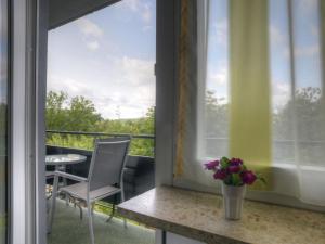 balcón con mesa, silla y ventana en Holiday Home Möllmann by Interhome en Bromskirchen
