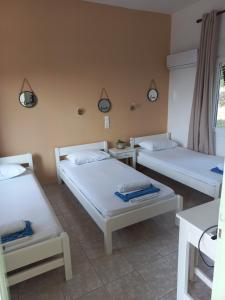 a room with three beds and a window at Stafylos Rooms in Stafylos