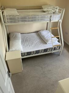 a bunk bed with two white pillows on it at Wendy Lodge- Chalet Cottage in Padstow