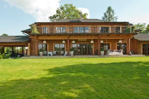 a large wooden house with a large yard at Dworek San Maryno in Jedlnia-Letnisko