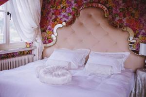 a white bed with a large headboard and pillows at Dworek San Maryno in Jedlnia-Letnisko