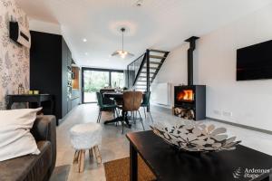 a living room with a fireplace and a table at Arbre Epine in Sart-lez-Spa