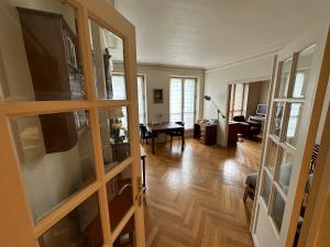 ein Wohnzimmer mit Holzböden und Glastüren in der Unterkunft 70 sqm apartment in 75008 Paris in Paris