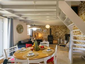 a dining room and living room with a table and chairs at Holiday Home La petite Iroise by Interhome in Plogoff
