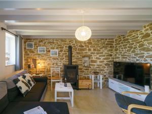 a living room with a couch and a stone wall at Holiday Home La petite Iroise by Interhome in Plogoff