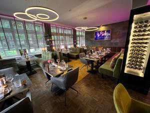 a restaurant with tables and chairs and a bar at Hotel Am Schloss Ahrensburg in Ahrensburg