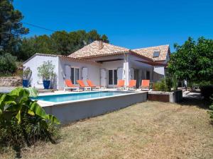 a villa with a swimming pool in front of a house at Holiday Home Les Eaux Claires by Interhome in Salernes