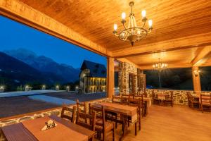 a dining area with tables and chairs on a patio at Theth Kompleksi Gjoni in Theth