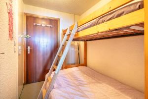 a bedroom with two bunk beds and a door at Le Vernon - Studio vue montagne près des pistes in Chamrousse