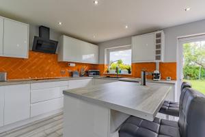 a kitchen with white cabinets and a large kitchen island at Jodi's Bungalow - Garden and Parking in Nottingham