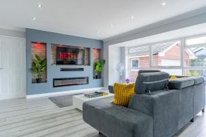 ein Wohnzimmer mit einem Sofa und einem TV in der Unterkunft Jodi's Bungalow - Garden and Parking in Nottingham