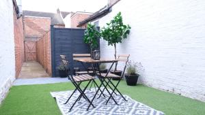 a patio with a table and two chairs on the grass at Modern Two Bedroom By Keysleeps Short Lets Northampton With Free Parking Garden Contractor Leisure 