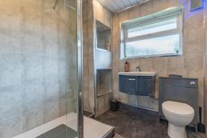 ein Bad mit einer Dusche, einem WC und einem Waschbecken in der Unterkunft Jodi's Bungalow - Garden and Parking in Nottingham