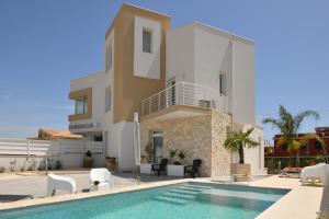 eine Villa mit einem Swimmingpool vor einem Haus in der Unterkunft Apartment Laura in Avola