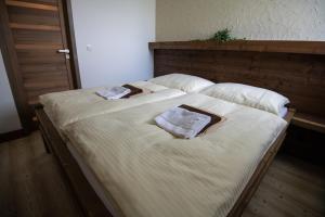 a large bed with two towels on top of it at Nestville Apartments in Hniezdne