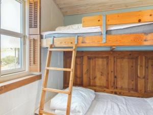 a bunk bed in a tiny house with a ladder at Holiday Home Bedrija - 200m from the sea in NW Jutland by Interhome in Løkken