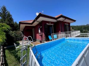 a villa with a swimming pool in front of a house at Apartment Villa Michelle by Interhome in Bardino Nuovo