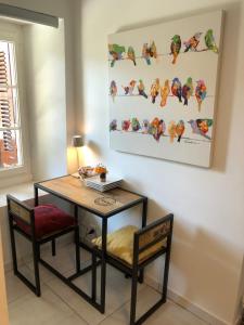 a dining room table with two chairs and a painting on the wall at Soumia in Territet