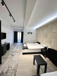 a bedroom with a bed and a couch and a table at Hotel FOCUS in Prilep