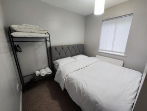 een witte slaapkamer met een bed en een spiegel bij Harmony in Bicester in Bicester