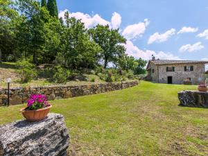 eine Steinmauer mit einem Blumentopf darauf in der Unterkunft Holiday Home La Querciolaia by Interhome in Pieve a Presciano