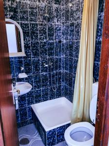 Baño de azulejos azules con aseo y lavamanos en Peaceful, Cosy Tivat Guesthouse en Tivat