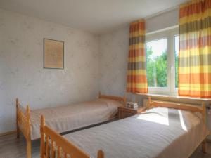 Apartment Magy by Interhome في Bromskirchen: سريرين في غرفة مع نافذة