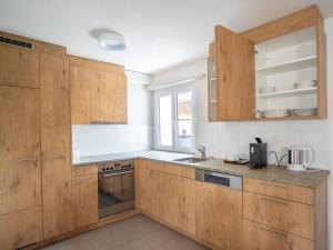 a kitchen with wooden cabinets and a sink at Apartment Hotel Restaurant La Tgoma by Interhome in Lenz