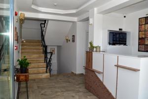 einen Flur mit einer Treppe mit weißen Wänden in der Unterkunft Maslin Butik Otel in Gokceada Town