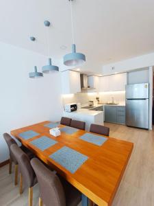 a kitchen and dining room with a wooden table and chairs at Q Conzept apt 2br new in Kata Beach