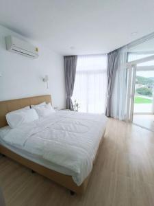a bedroom with a large bed and a large window at Q Conzept apt 2br new in Kata Beach
