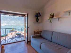 ein Wohnzimmer mit Couch und Balkon in der Unterkunft Apartment Niki by Interhome in Domaso