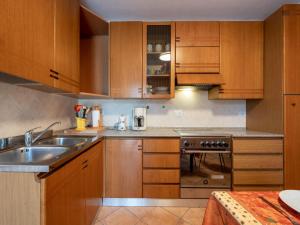 a kitchen with wooden cabinets and a sink at Holiday Home Vallegra by Interhome in Cortiglione