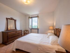 a bedroom with a large bed with a mirror and a dresser at Holiday Home Vallegra by Interhome in Cortiglione