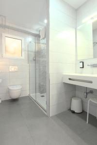 a bathroom with a shower and a toilet and a sink at Hotel La Milagrosa in Alicante